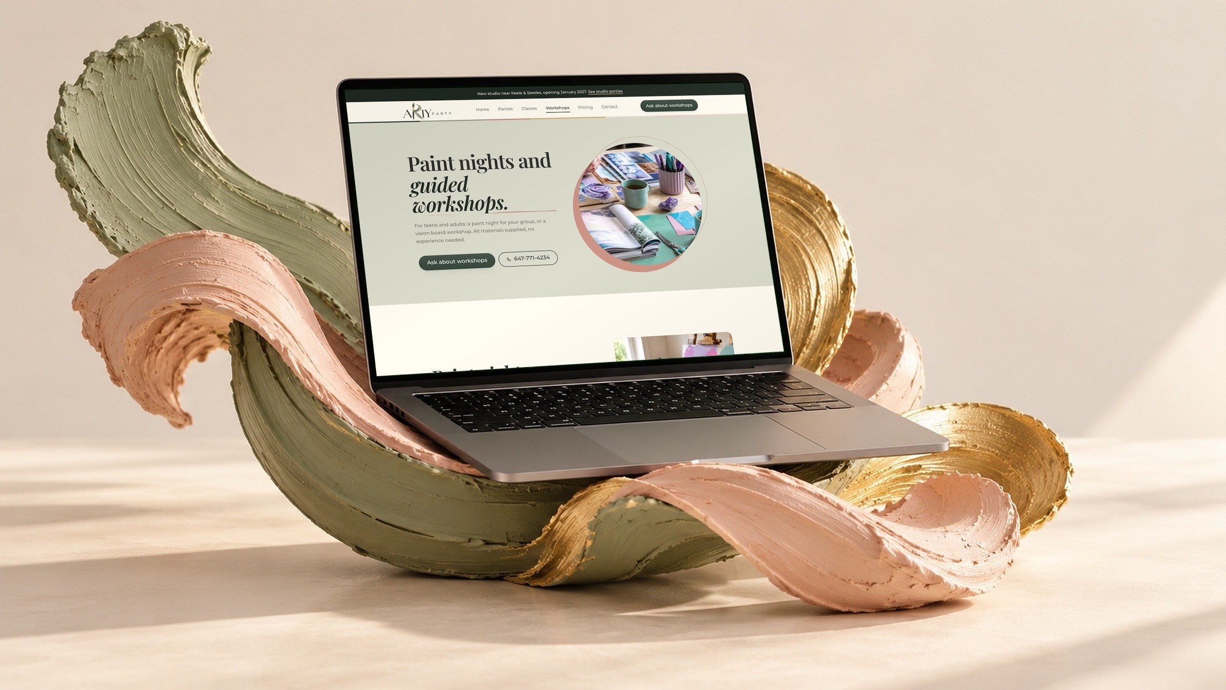 The paint nights and workshops page on a laptop, cradled by sculpted brushstrokes.